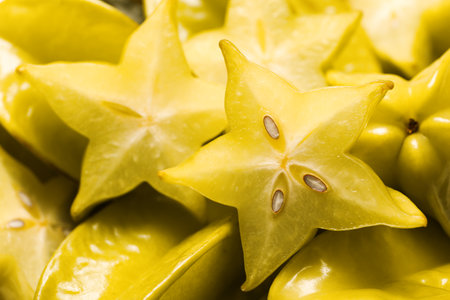 Cut and whole carambolas as background, closeupの写真素材