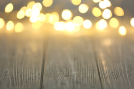 Beautiful lights on wooden table, blurred view. Space for textの写真素材
