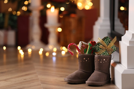 Boots filled with sweets and gift on floor in room, space for text. Saint Nicholas Dayの写真素材