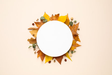 Flat lay composition with autumn leaves and blank card on light background, space for textの写真素材