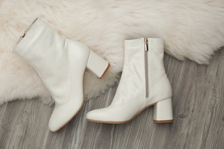 Pair of stylish leather shoes on faux fur, flat lay