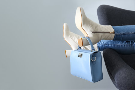 Woman wearing stylish leather shoes with bag indoors, closeup. Space for textの写真素材