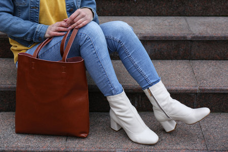 Woman in stylish leather shoes with bag on stairs outdoors, closeupの写真素材