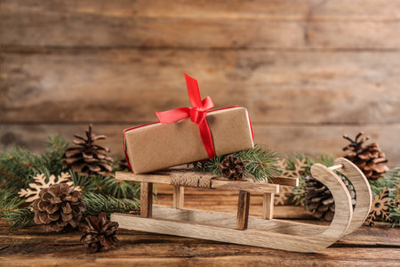 Beautiful Christmas composition with miniature sleigh on wooden tableの写真素材