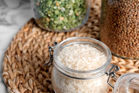 Glass jar with uncooked rice on tableの写真素材