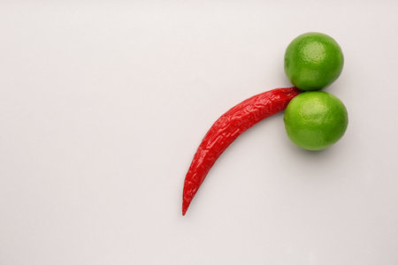 Chili pepper and limes symbolizing male sexual organ on white background, flat lay with space for text. Potency problemの写真素材