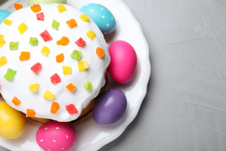 Beautiful Easter cake and painted eggs on light gray table, top viewの写真素材
