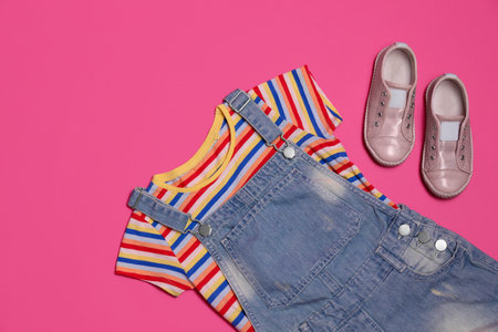 Child's clothes and shoes on pink background, flat layの写真素材