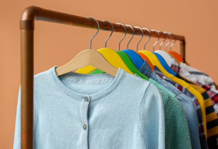 Rack with stylish children clothes on beige background, closeupの写真素材