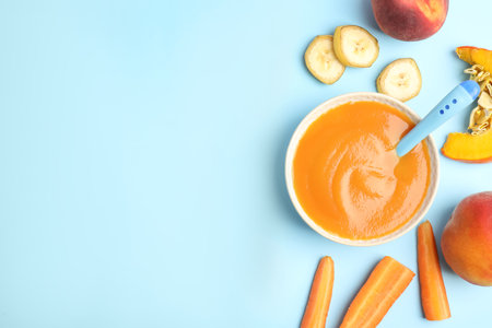 Flat lay composition with healthy baby food and ingredients on light blue background. Space for textの写真素材
