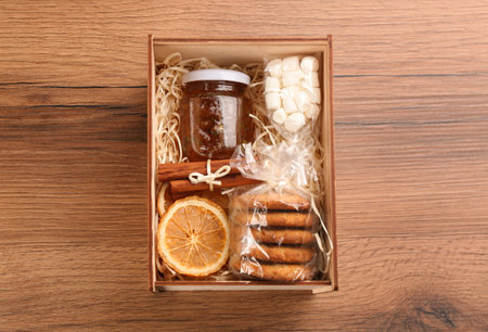 Box with stylish craft gift set on wooden table, top viewの写真素材