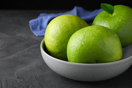 Fresh ripe sweeties in bowl on gray table, closeupの写真素材