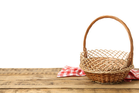 Wicker basket and towel on wooden table against white background, space for text. easter itemの写真素材