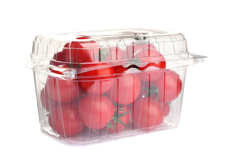 Fresh ripe cherry tomatoes in plastic container on white backgroundの写真素材