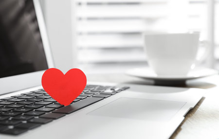 Red heart on laptop in office, space for text. Valentine's day celebrationの写真素材