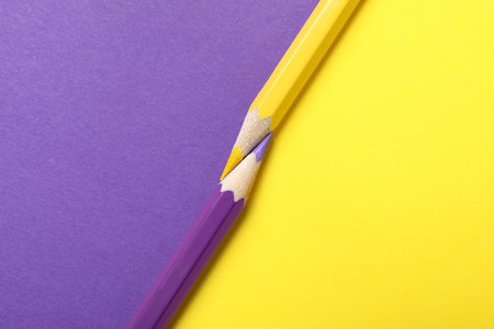 Two pencils on yellow and purple background, top viewの写真素材