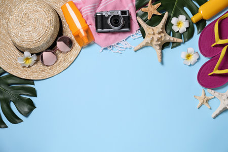 Flat lay composition with beach items on light blue background. Space for textの写真素材