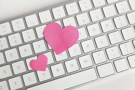 Keyboard with pink hearts on white table, top view. Valentine's day celebrationの写真素材