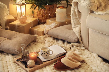 Wooden tray with cocoa, candle and notebook in room decorated for Christmasの写真素材