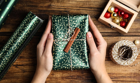 Woman with gift box at wooden table, top viewの写真素材
