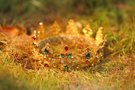 Beautiful golden crown on fresh green grass outdoors, closeup. fantasy itemの写真素材