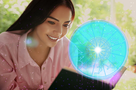 Young woman reading book outdoors and illustration of zodiac wheel with astrological signsの写真素材