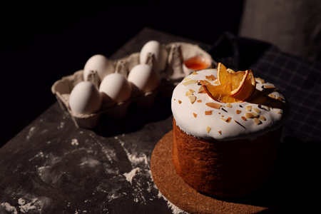 Traditional decorated Easter cake on black table. Space for text