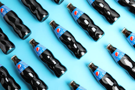 MYKOLAIV, UKRAINE - FEBRUARY 08, 2021: Glass bottles of Pepsi on light blue background, flat layのeditorial素材