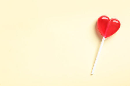 Sweet heart shaped lollipop on beige background, top view with space for text. Valentine's day celebrationの写真素材