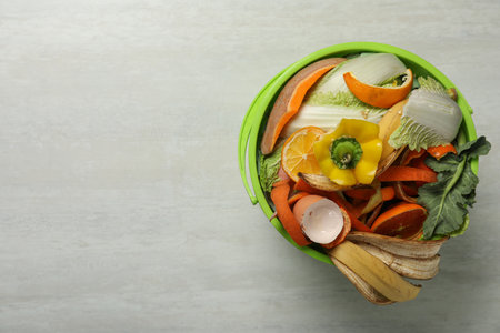 Natural garbage in trash bin on light background, top view with space for text. Composting of organic wasteの写真素材