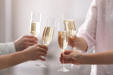 People clinking glasses of champagne against blurred background, closeupの写真素材