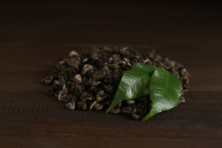 Heap of dried green tea leaves on wooden table, closeupの写真素材