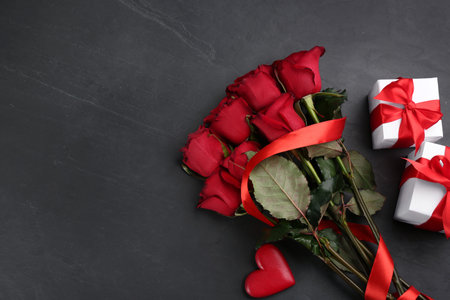Flat lay composition with beautiful red roses and gift boxes on black background, space for text. Valentine's Day celebrationの写真素材