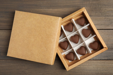 Tasty heart shaped chocolate candies on wooden table, flat lay. happy valentines dayの写真素材