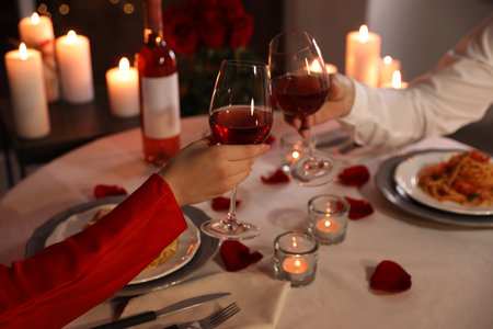 Couple clinking glasses of wine indoors, closeup. romantic dinnerの写真素材