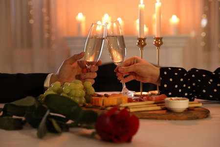 Couple clinking glasses of champagne in restaurant, closeup. romantic dinnerの写真素材