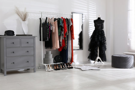 Rack with collection of festive beautiful clothes in stylish room interiorの写真素材