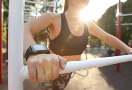 Woman wearing modern smart watch during training outdoors, closeupの写真素材