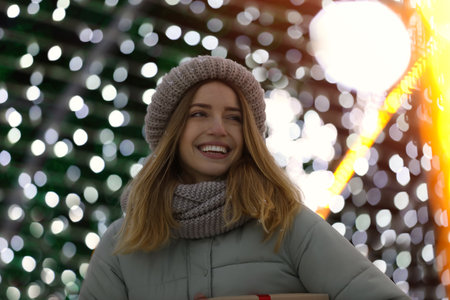 Happy young woman near festive lights. christmas celebrationの写真素材