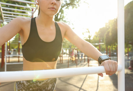 Woman wearing modern smart watch during training outdoors, closeupの写真素材