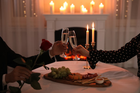 Couple clinking glasses of champagne in restaurant, closeup. romantic dinnerの写真素材