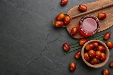 Flat lay composition with palm oil and fresh fruits on black table. Space for textの写真素材