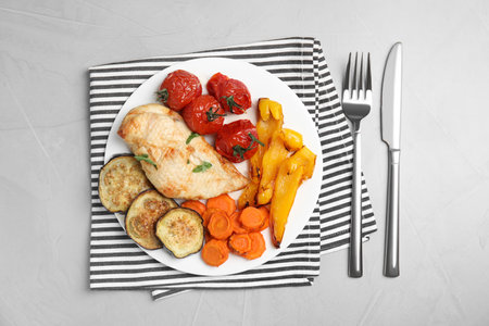 Delicious cooked chicken and vegetables served on gray table, flat lay. Healthy meals from air fryerの写真素材