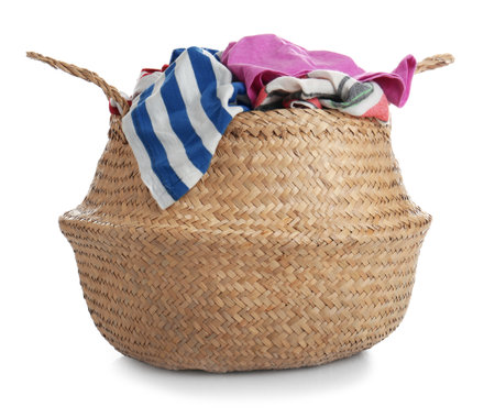 Wicker laundry basket with kitchen towels isolated on whiteの写真素材