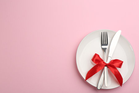 Beautiful table setting on pink background, top view with space for text. Valentine's Day dinnerの写真素材