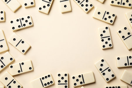 Frame of classic domino tiles on beige background, flat lay. Space for textの写真素材