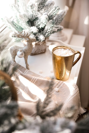 Golden cup of cocoa and Christmas decor on window sill indoorsの写真素材