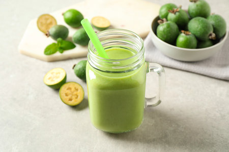 Fresh feijoa smoothie in mason jar on light table, closeupの写真素材