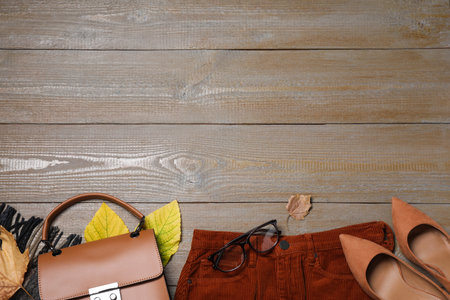 Flat lay composition with autumn clothes and accessories on wooden table. Space for textの写真素材
