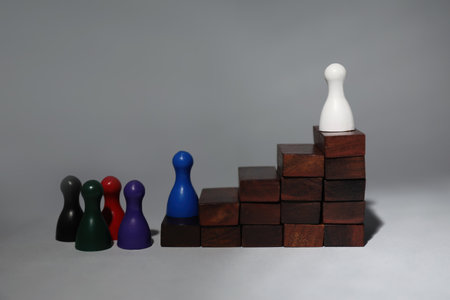 White chess piece on top of wooden stairs against gray background